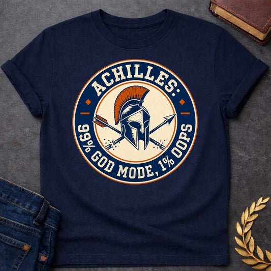 Navy T-Shirt with a circular badge design in navy blue, cream, and burnt orange featuring a Greek Corinthian helmet with orange horsehair crest, crossed by two arrows. Styled like a vintage achievement badge. Text reads 'ACHILLES:' at top, '99% GOD MODE, 1% OOPS' at bottom. Humorously references Achilles and his famous vulnerability—his heel—suggesting he was nearly invincible (99% in 'god mode') except for one fatal weakness (1% 'oops'). Distressed, retro aesthetic mimics vintage sports or gaming badges.