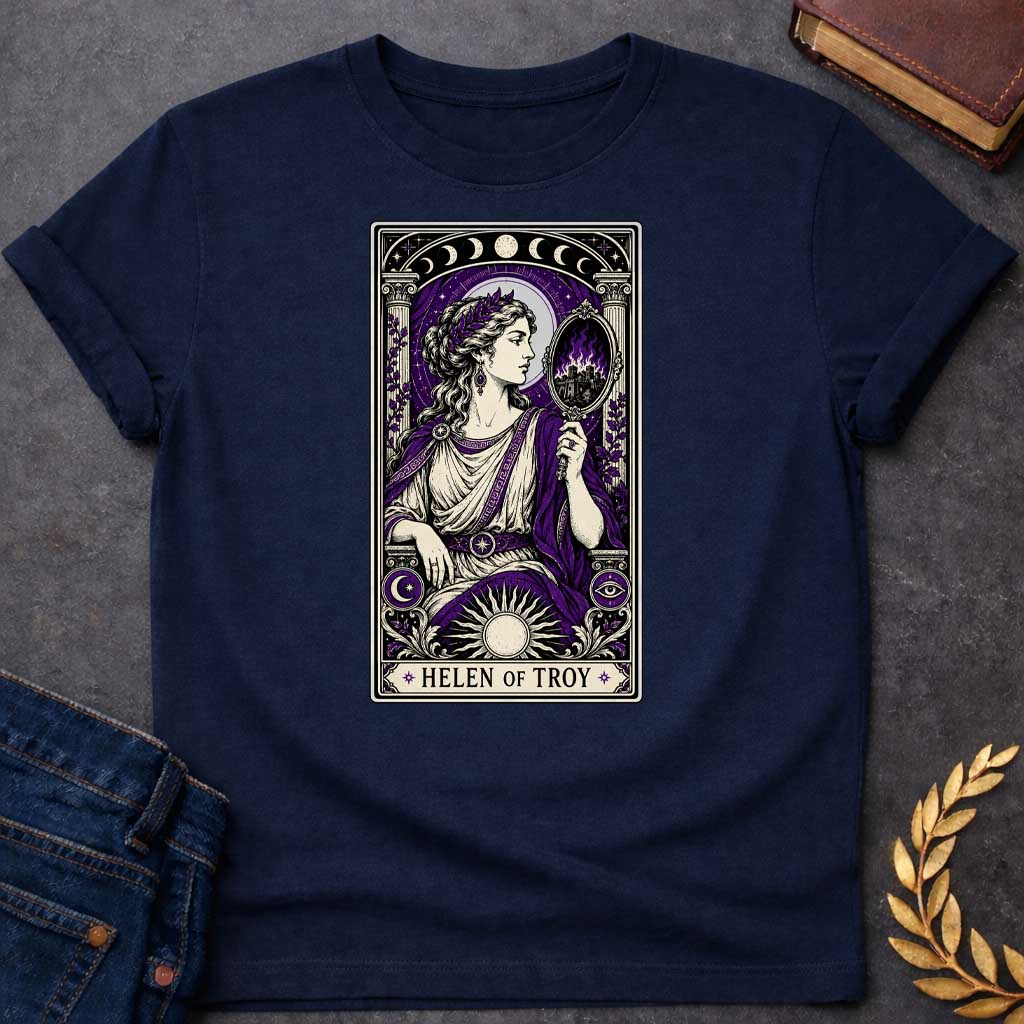Navy T-shirt with an intricate tarot card style graphic featuring Helen of Troy in a Dark Academia aesthetic. She wears a laurel wreath, Greek tunic, and purple robe, holding a hand mirror that reflects a burning city in purple flames. The design has a black, cream, and deep purple color scheme with mystical elements like moon phases, a radiant sun, and an eye symbol. A banner at the bottom reads "HELEN OF TROY" between two stars