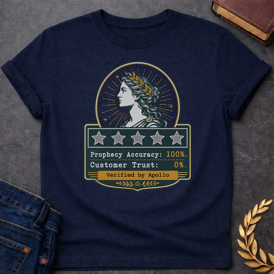 Navy T-shirt with a satirical Greek mythology badge referencing Cassandra. The top features a vector profile of a woman wearing a gold laurel wreath with a radiant sunburst behind her. Below, a dark plaque displays five empty review stars. The text reads: "Prophecy Accuracy: 100%." and "Customer Trust: 0%." in a typewriter font. A gold banner at the bottom is stamped with "Verified by Apollo."