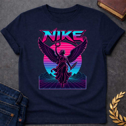 Navy T-shirt with a Vaporwave-style illustration of Nike, the Greek goddess of victory, rendered in neon magenta and cyan. She wears flowing robes with large detailed wings, holding a laurel wreath and palm frond. Bold angular text 'NIKE' appears above in magenta lettering. Geometric mountains and grid landscape create a synthwave aesthetic. Horizontal gradient bands in magenta, purple, and cyan evoke 1980s digital design. Blends classical mythology with modern vaporwave art.