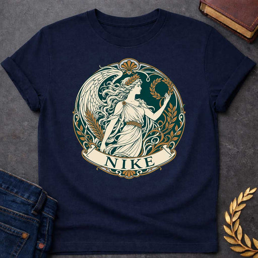 Navy T-shirt with a Classical medallion design in teal, cream, and gold depicting Nike, the Greek goddess of victory. She wears a flowing chiton and holds a laurel wreath, shown in profile with long wavy hair crowned by another laurel wreath. Large detailed wings extend behind. Ornate Art Nouveau border features scrollwork, gold floral elements, and Greek key patterns. Banner below reads 'NIKE' in teal. Celebrates victory, achievement, and athletic glory in classical style.