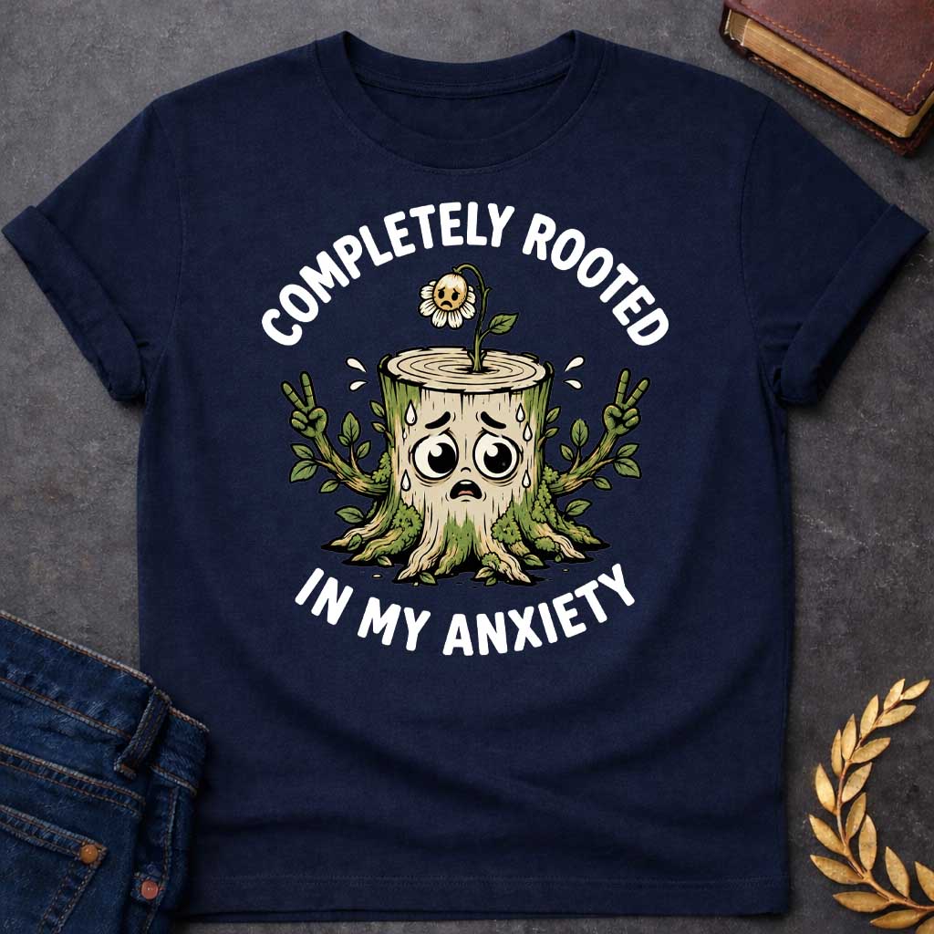 Navy T-shirt with a cottagecore-style Greek mythology t-shirt design featuring an engraving illustration of a dryad. The flowing hair intricately weaves into a robust network of tree roots below. Arched elegantly above the portrait is the text "COMPLETELY ROOTED" in a clean white serif font.