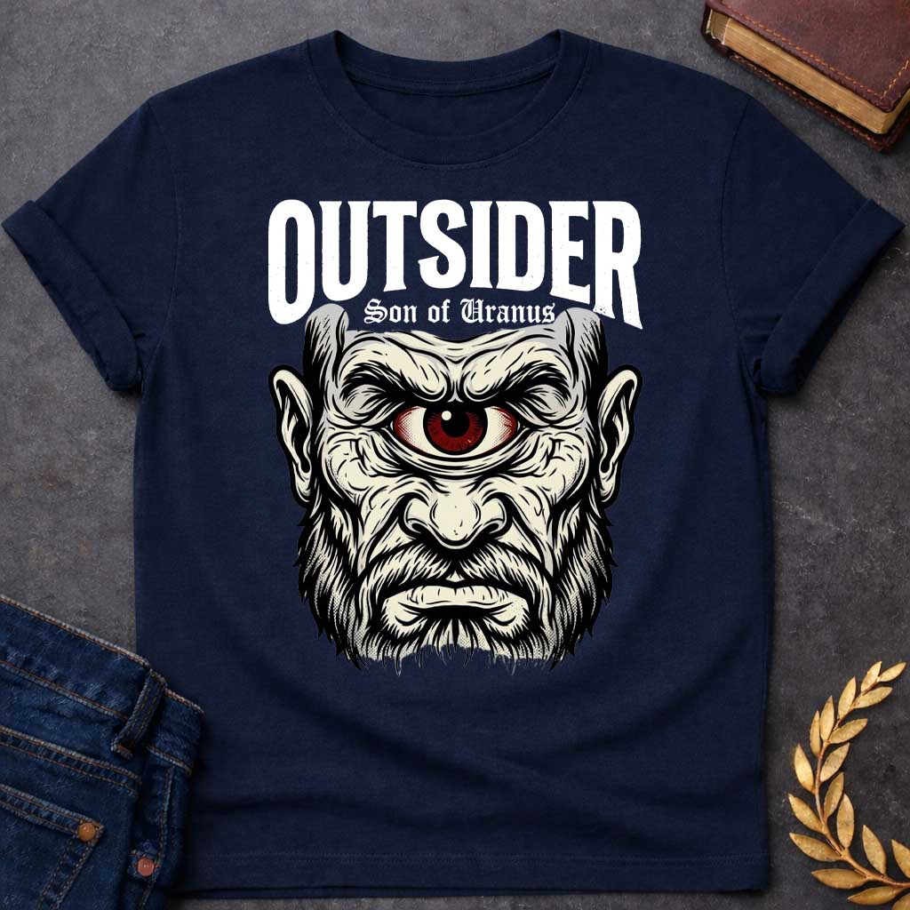 Navy T-shirt with a Bold typography design featuring a single-eyed Titan face with fierce expression. Thick white beard and long flowing hair frame a menacing red eye with intense gaze. Black and white engraving style with intricate line work emphasizing the character's otherworldly nature. Text reads 'OUTSIDER' and 'Son of Uranus' referencing the Titans of Greek mythology. Celebrates mythological outsider status, divine rebellion, and powerful, untamed forces beyond mortal comprehension.