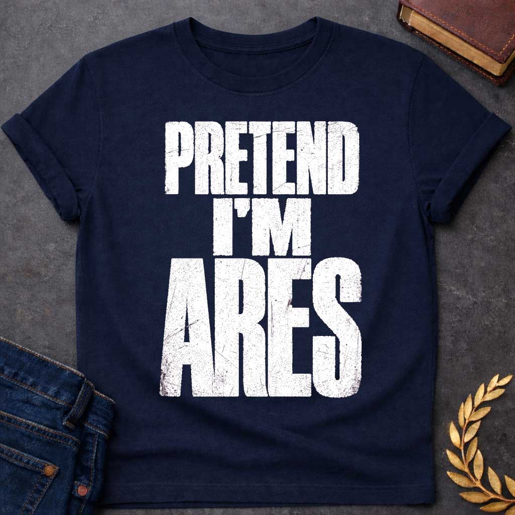 Navy t-shirt with a Pretend I’m Ares Greek mythology design featuring bold distressed white typography on a transparent background. The stacked text reads “PRETEND I’M ARES” in a rugged vintage block font, creating a humorous Greek god design inspired by Ares, the god of war, courage, battle, and martial strength.