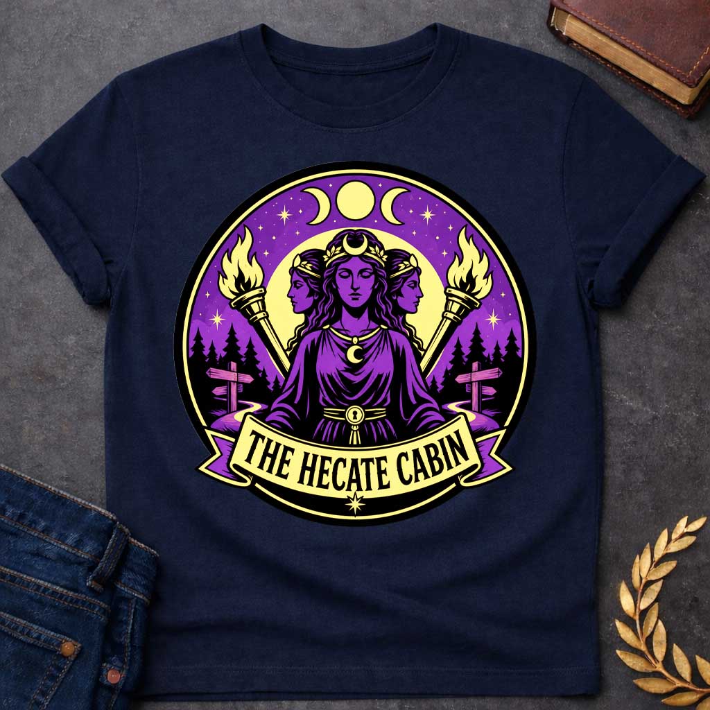 Navy t-shirt with a Hecate Greek mythology design featuring the triple goddess with three faces, crescent moon symbols, glowing torches, stars, and a mystical purple night sky. Forest silhouettes and crossroads signs represent Hecate’s connection to magic and crossroads, framed in a circular camp-style emblem with the text “The Hecate Cabin.”
