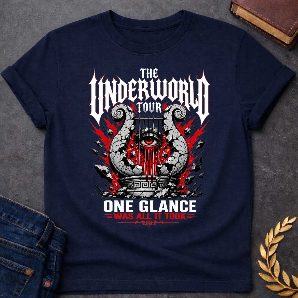 Navy t-shirt in heavy metal band-poster style: a cracked stone lyre with a bleeding red eye at its center sits atop a Greek pedestal, framed by jagged red lightning bolts and scattered rubble. Gothic spiked white lettering and bold red accent text complete the design