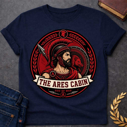 Navy t-shirt with a Ares Greek mythology cabin design featuring the god of war in a Spartan-style helmet and armor, framed by a spear, shield with a fierce boar, and laurel branches. Bold red, black, and cream circular camp-style emblem includes the text “The Ares Cabin” and “God of War,”
