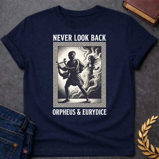 Navy t-shirt in engraved woodcut style: Orpheus strides forward carrying a lyre while Eurydice dissolves into smoke and shadow behind him, reaching out. The scene sits within a Greek key-patterned rectangular border, framed by bold serif text above and below, on a cream and black palette.
