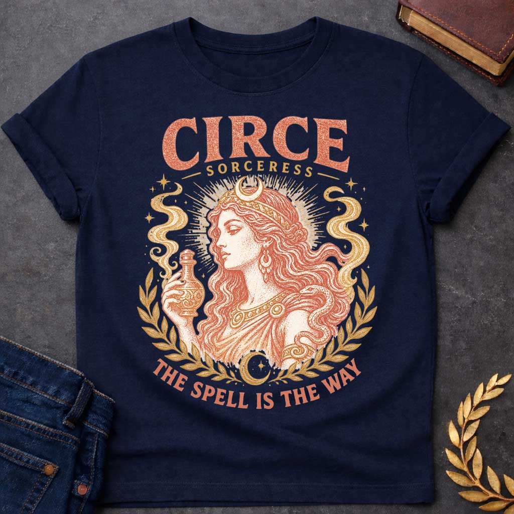 Navy t-shirt with a Vintage Greek mythology design featuring Circe, the legendary sorceress, holding a potion bottle with a snake coiled around her arm. Crescent moons, stars, mystical smoke, and laurel branches frame the portrait with the text “Circe Sorceress” and “The Spell Is the Way” in a distressed antique style.
