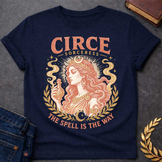 Navy t-shirt with a Vintage Greek mythology design featuring Circe, the legendary sorceress, holding a potion bottle with a snake coiled around her arm. Crescent moons, stars, mystical smoke, and laurel branches frame the portrait with the text “Circe Sorceress” and “The Spell Is the Way” in a distressed antique style.