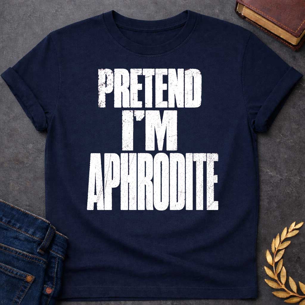 Navy t-shirt with a Pretend I’m Aphrodite Greek mythology design featuring bold distressed white typography on a transparent background. The stacked text reads “PRETEND I’M APHRODITE” in a rugged vintage block font, creating a simple humorous design inspired by Aphrodite, the Greek goddess of love and beauty.