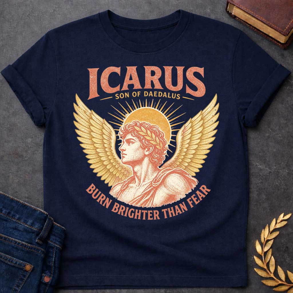 Navy t-shirt with a Vintage Icarus Greek mythology design featuring the son of Daedalus in profile with large golden wings, a laurel crown, and a radiant sun behind him. Distressed coral and gold artwork gives the design an antique classical look, with bold text reading “Icarus Son of Daedalus” and “Burn Brighter Than Fear.”