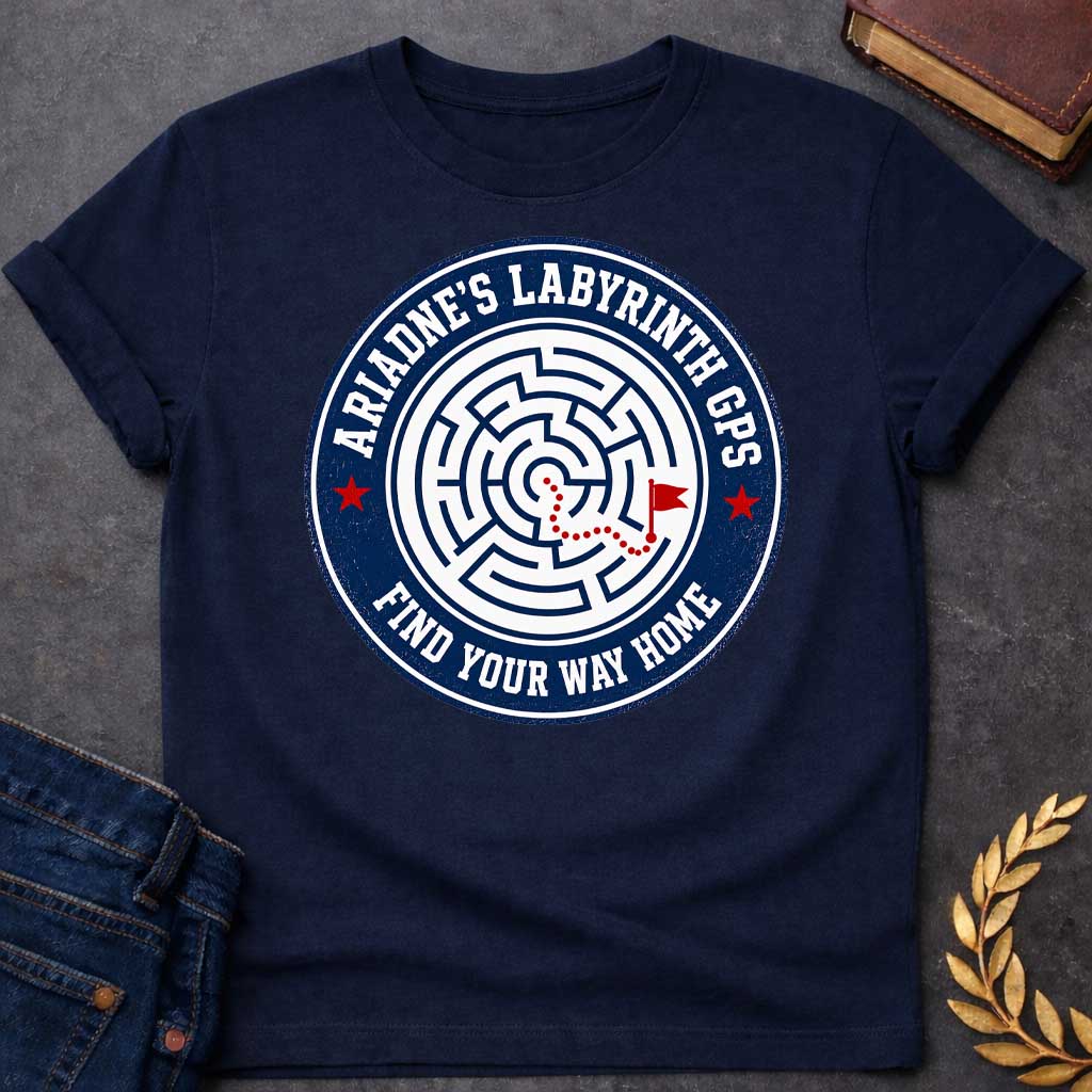 Navy T-shirt with A Circular emblem with concentric maze in navy and white, featuring a red dotted path through the labyrinth toward a flag marker. Red stars accent the design. Text reads 'Ariadne's Labyrinth GPS' around the border and 'Find Your Way Home' below. Merges Greek mythology with modern GPS technology, presenting the legendary thread as contemporary guidance. Celebrates finding home through challenging mazes.
