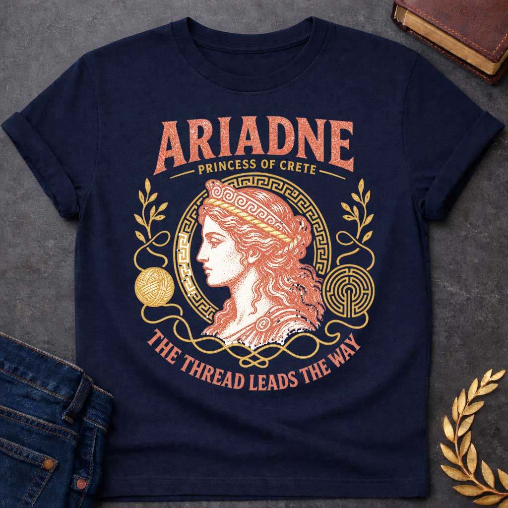 Navy t-shirt with a Vintage Greek mythology design featuring Ariadne, Princess of Crete, in a classical portrait framed by a Greek key border, golden thread, yarn, laurel branches, and a labyrinth. Warm coral and gold engraving-style artwork is paired with the phrase "The Thread Leads the Way," inspired by Ariadne's role in helping Theseus escape the Minotaur's labyrinth.
