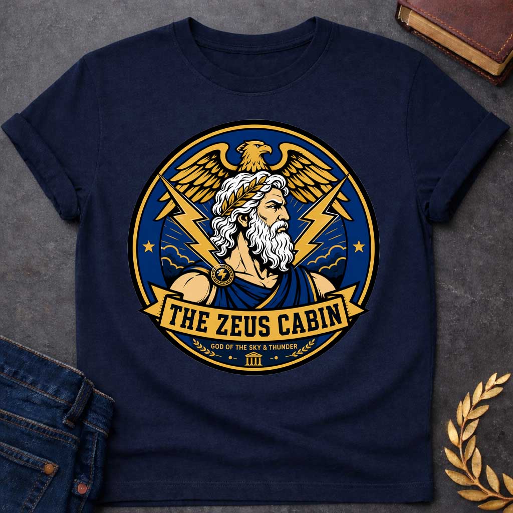 Navy t-shirt with a Zeus Greek mythology cabin design featuring the bearded god of the sky and thunder with a laurel crown, golden eagle, lightning bolts, storm clouds, and Greek temple symbol. Bold blue, gold, white, and black circular camp-style emblem includes the text “The Zeus Cabin” and “God of the Sky & Thunder.”