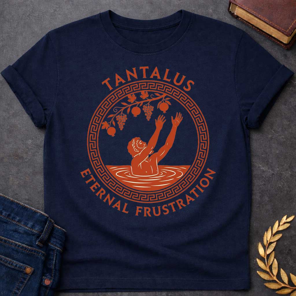 Navy t-shirt with An ancient Greek pottery-style t-shirt graphic for "enternal frustration.jpg". Inside a circular terracotta frame with a classic meander key pattern, a figure stands waist-deep in water reaching both hands up toward dangling grapes and pomegranates. Arched above the emblem, bold terracotta text reads "TANTALUS", while the phrase "ETERNAL FRUSTRATION" curves around the bottom in matching serif typography.