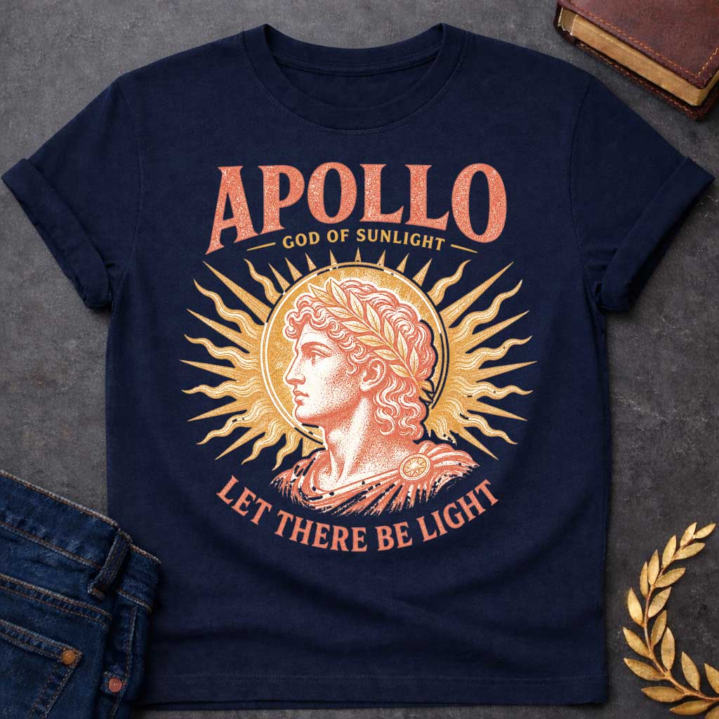 Navy t-shirt with a Vintage Greek mythology design featuring Apollo, god of sunlight, in a classical portrait wearing a laurel crown. A radiant golden sunburst frames the god in warm coral and gold engraving-style artwork. Bold text reads "Apollo – God of Sunlight" and "Let There Be Light," celebrating the legendary Olympian god.