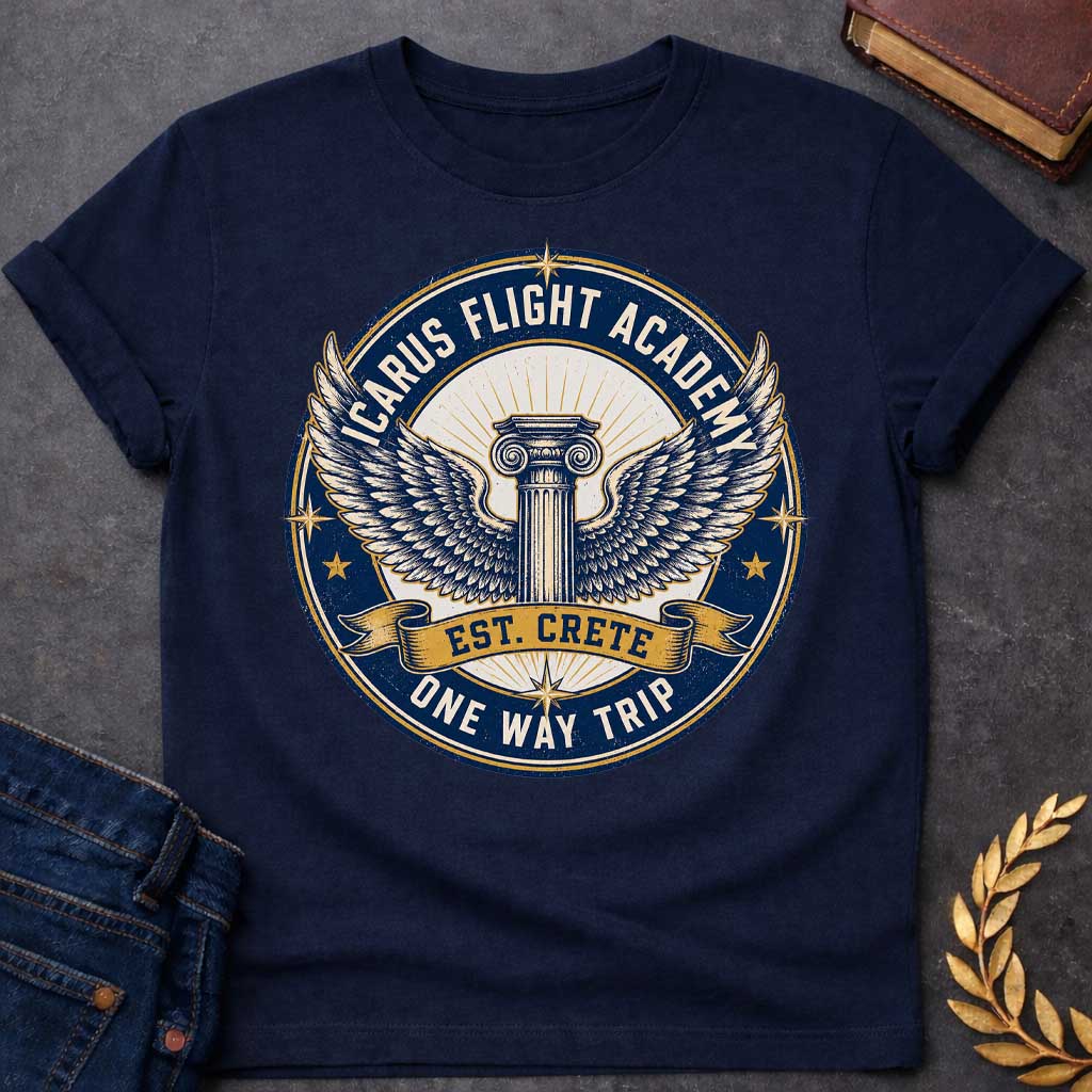 Navy t-shirt A circular, distressed vintage emblem design. At the center of a cream circle, a classic Greek Ionic column sprouts a large pair of detailed, spreading wings. A dark blue outer ring features the text "ICARUS FLIGHT ACADEMY" at the top and "ONE WAY TRIP" at the bottom. A golden banner across the center reads "EST. CRETE," adding a dark humor twist to the mythological flight.