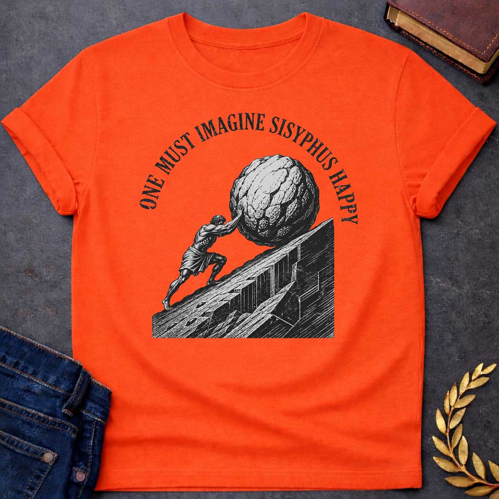 Orange T-Shirt with a high-contrast, black-and-white graphic design. The illustration features a woodcut-style depiction of Sisyphus straining to push a massive, craggy boulder up a steep, jagged mountainside. Arched in a bold, weathered serif font over the top of the illustration is the text "ONE MUST IMAGINE SISYPHUS HAPPY,"