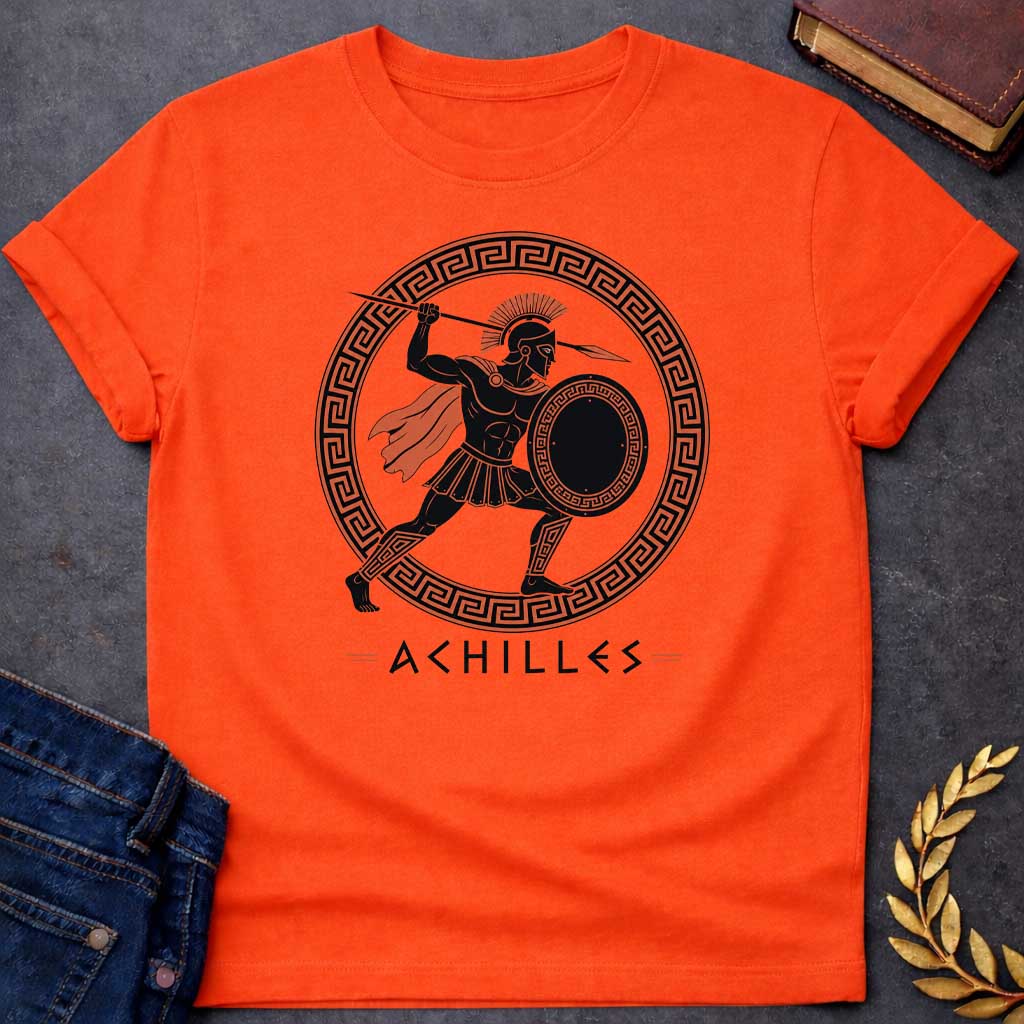 Orange T-Shirt with an ancient Greek red-figure pottery style illustration of Achilles in dynamic battle pose. The muscular figure is rendered in black silhouette with terracotta-orange details, wearing a crested Corinthian helmet, pleated skirt, flowing cape, and greaves. He holds a round shield with Greek key pattern and raises a spear overhead. Enclosed in a circular border with orange and black meander pattern. Below, 'ACHILLES' is written in geometric font. Evokes classical Greek pottery art.