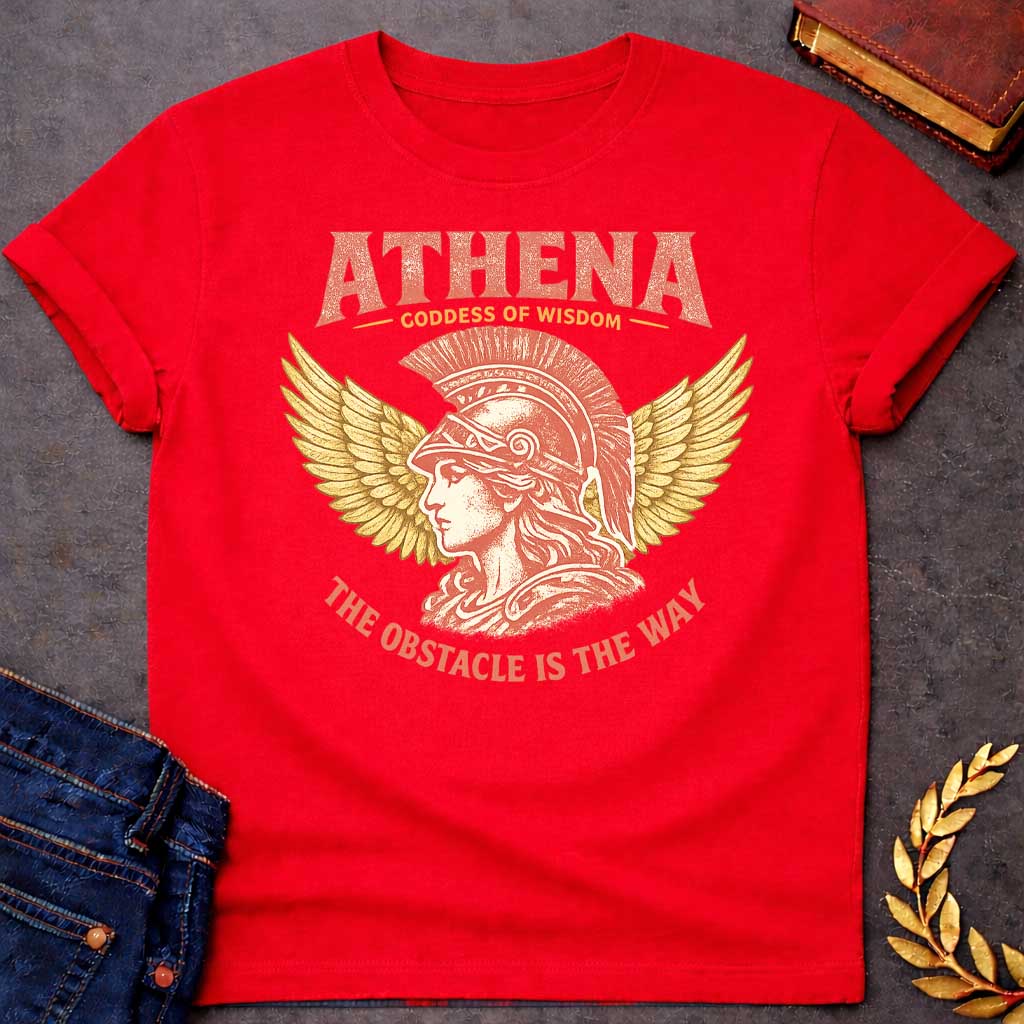 Red t-shirt graphic featuring a side-profile illustration of Athena wearing a Corinthian helmet with a red plume, flanked by large golden wings. Text reads "ATHENA – Goddess of Wisdom" arched above and "The Obstacle Is the Way" curved below, in a vintage Greek mythology style with rose and gold tones