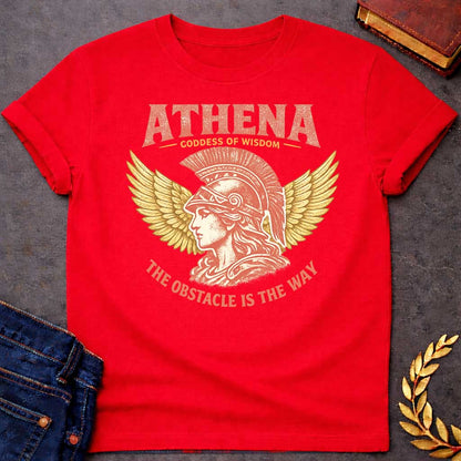 Red t-shirt graphic featuring a side-profile illustration of Athena wearing a Corinthian helmet with a red plume, flanked by large golden wings. Text reads "ATHENA – Goddess of Wisdom" arched above and "The Obstacle Is the Way" curved below, in a vintage Greek mythology style with rose and gold tones