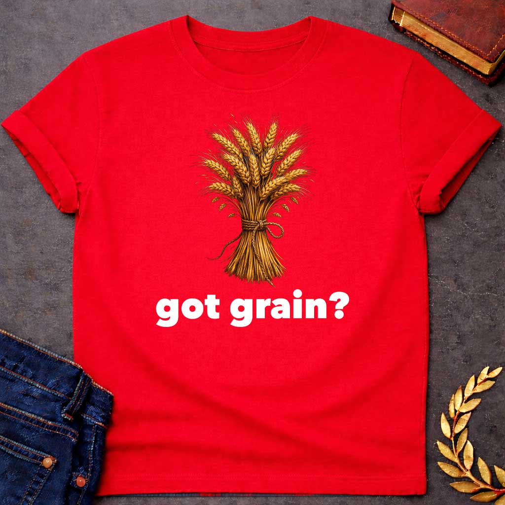 Red T-shirt graphic featuring a detailed realistic illustration of a golden wheat sheaf tied together with a twisted rope bow, set against a white background, with bold black text below reading "got grain?" in a humorous nod to Demeter, Greek Goddess of the Harvest