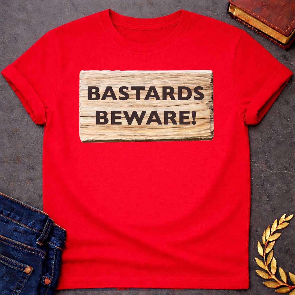 Red T-shirt graphic featuring a realistic illustration of a weathered and splintered wooden plank sign with bold dark brown text reading "Bastards Beware!" in a humorous nod to Hera, the Greek Queen of the Gods, known for her jealous wrath toward Zeus's illegitimate children
