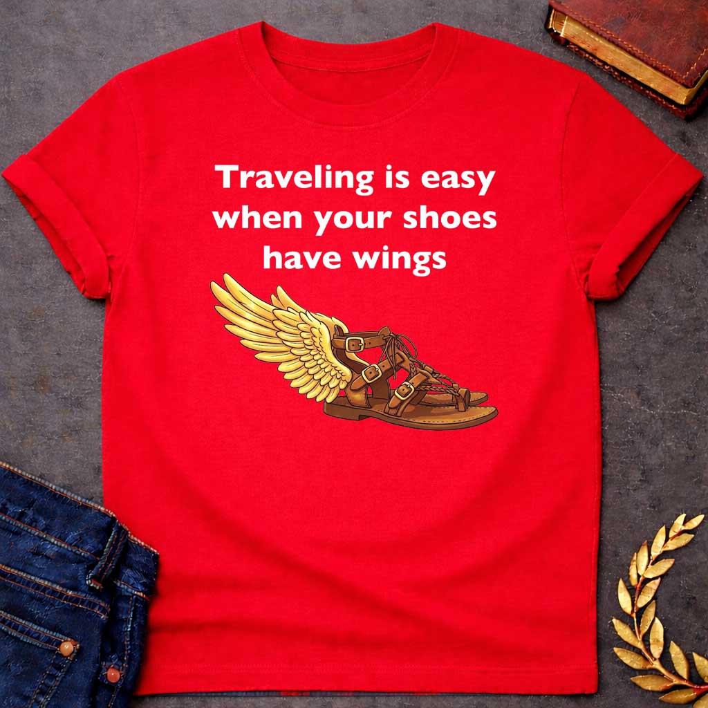 Red T-shirt graphic featuring bold white text reading "Traveling is easy when your shoes have wings" above a detailed illustration of Hermes' winged sandal, depicted as a brown leather gladiator sandal with gold buckles and braided lacing, with a large golden wing extending from the ankle — a humorous reference to the talaria, the iconic flying sandals of Hermes, the Greek Messenger God
