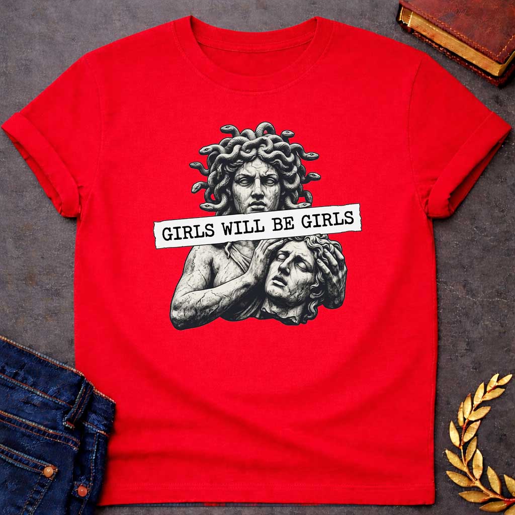 Red T-shirt graphic in black and white featuring a detailed stone sculpture-style illustration of Medusa with snake hair looming above a distressed male figure clutching his head in anguish, with a torn paper banner across the middle reading "Girls Will Be Girls" in bold typewriter font — a humorous feminist nod to the Greek mythology story of Medusa