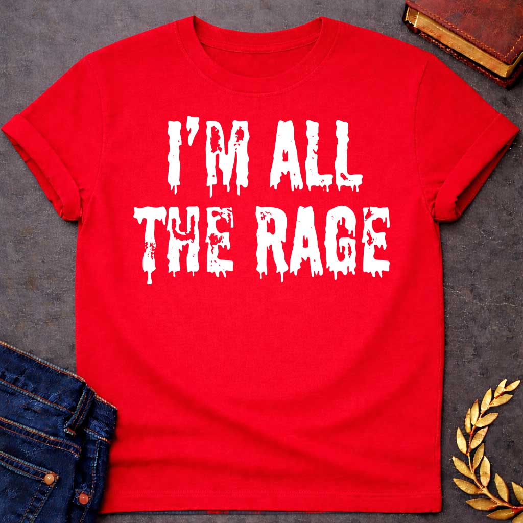 Red T-shirt graphic in white featuring large dripping horror-style text reading "I'm All the Rage" — a double entendre playing on both popular trends and the furious wrath of Ares, the Greek God of War, rendered in a distressed melting font