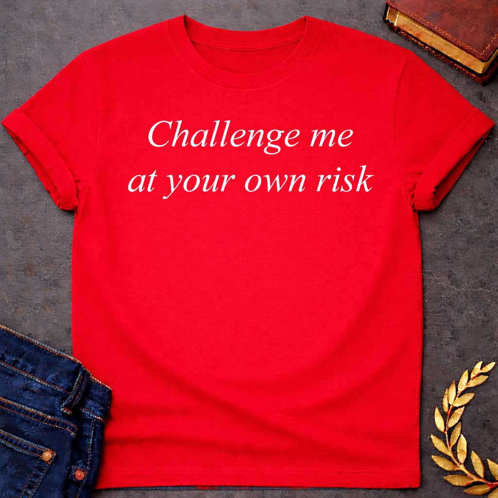 Red T-shirt graphic in white featuring large elegant italic serif text reading "Challenge me at your own risk" — a bold warning referencing Athena, the Greek Goddess of Wisdom and War Strategy