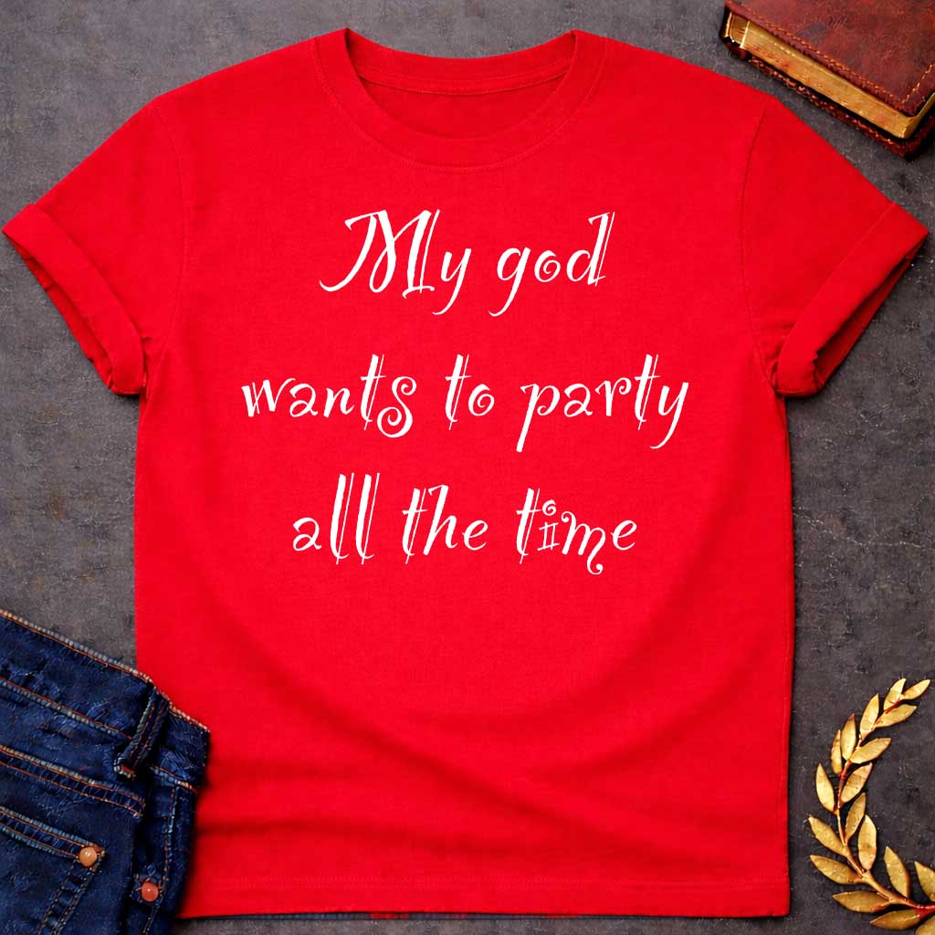 Red T-shirt graphic white text featuring whimsical hand-lettered calligraphy-style text reading "My god wants to party all the time" — a humorous nod to Dionysus, the Greek God of Wine and Revelry