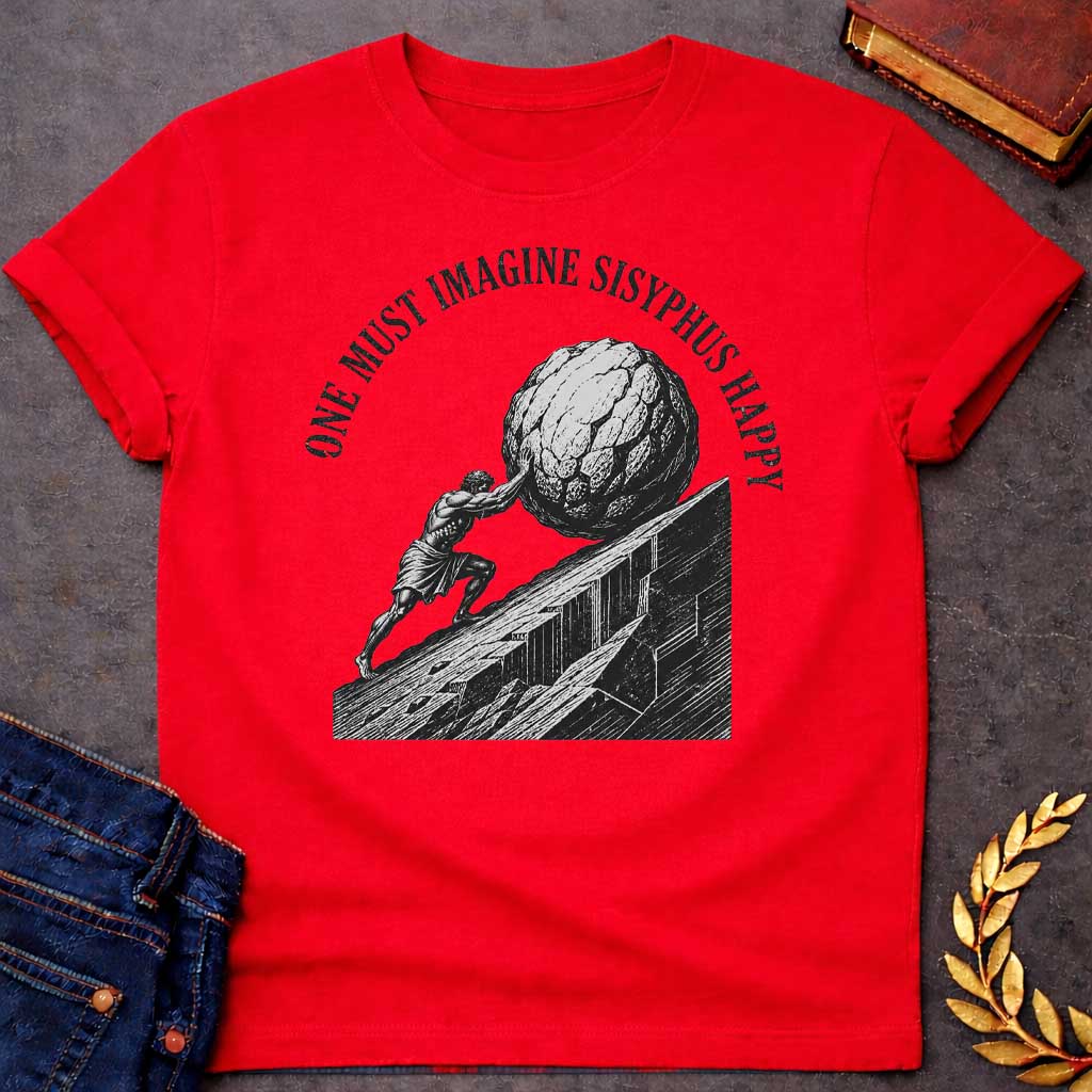 Red T-Shirt with a high-contrast, black-and-white graphic design. The illustration features a woodcut-style depiction of Sisyphus straining to push a massive, craggy boulder up a steep, jagged mountainside. Arched in a bold, weathered serif font over the top of the illustration is the text "ONE MUST IMAGINE SISYPHUS HAPPY,"