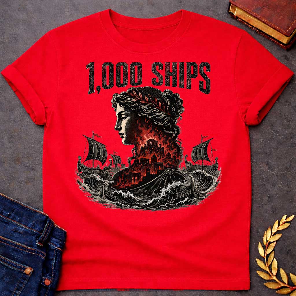 Red T-shirt with a dramatic illustration of Helen of Troy in profile with curly hair and red laurel crown. Her silhouette contains the burning city of Troy in red and black flames. Greek warships with red flags sail through turbulent waves on either side. Bold distressed text reads '1,000 SHIPS' above. References the famous phrase 'the face that launched a thousand ships' describing Helen's beauty that sparked the Trojan War.