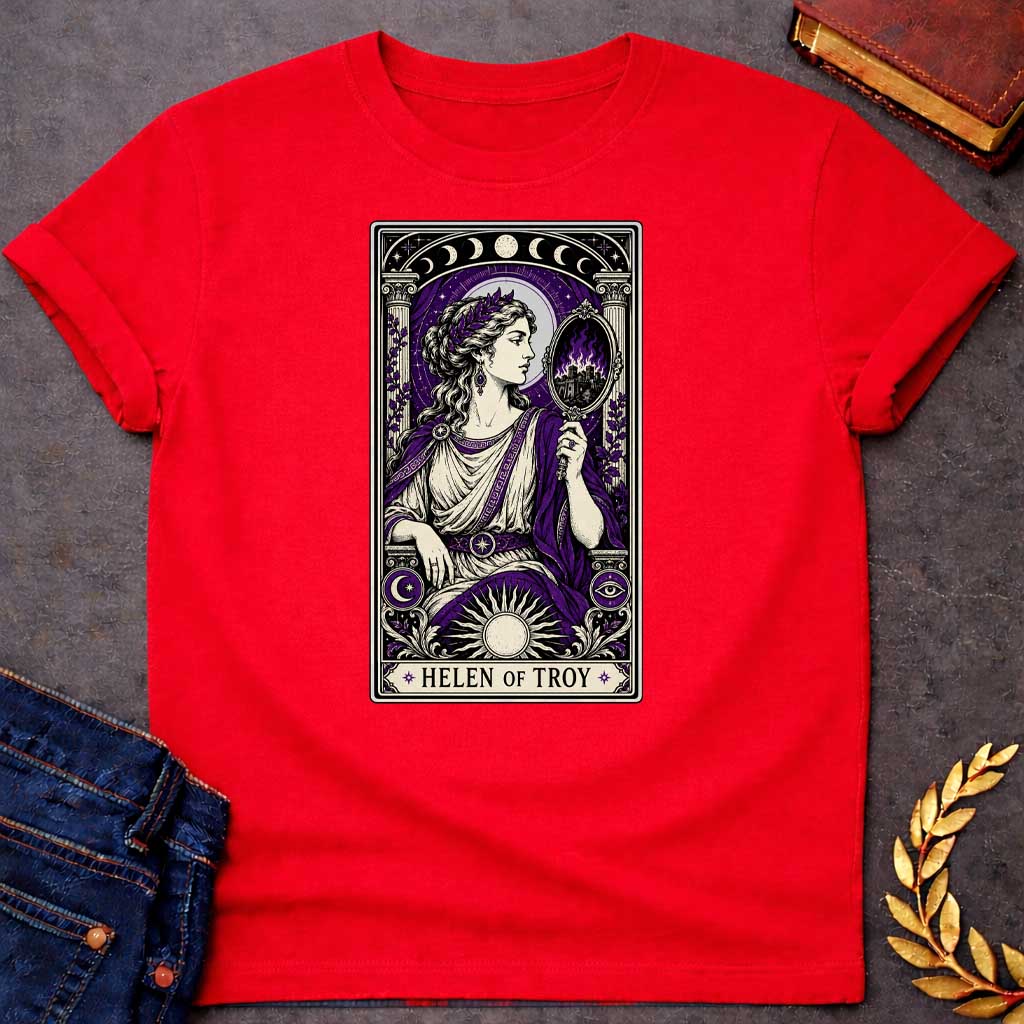 Red T-shirt with an intricate tarot card style graphic featuring Helen of Troy in a Dark Academia aesthetic. She wears a laurel wreath, Greek tunic, and purple robe, holding a hand mirror that reflects a burning city in purple flames. The design has a black, cream, and deep purple color scheme with mystical elements like moon phases, a radiant sun, and an eye symbol. A banner at the bottom reads "HELEN OF TROY" between two stars