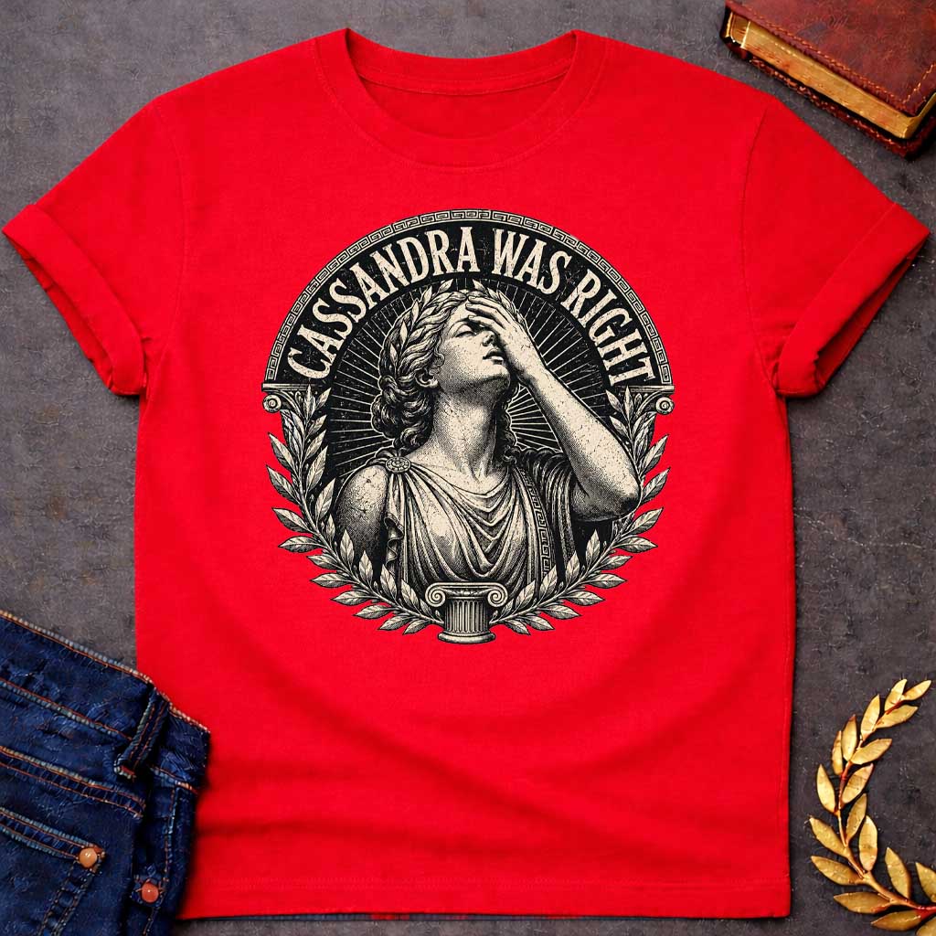 Red T-shirt with a classical engraving-style illustration of Cassandra, the Trojan prophetess, looking upward with one hand raised to her forehead in anguish. She wears flowing Greek robes with decorative brooch and Greek key pattern trim. Surrounded by laurel wreaths and flanked by Ionic columns. Radiating lines create a dramatic halo effect. Text 'CASSANDRA WAS RIGHT' curves along the top within a Greek key border. References the tragic myth of Cassandra, cursed to see the future but never be believed.