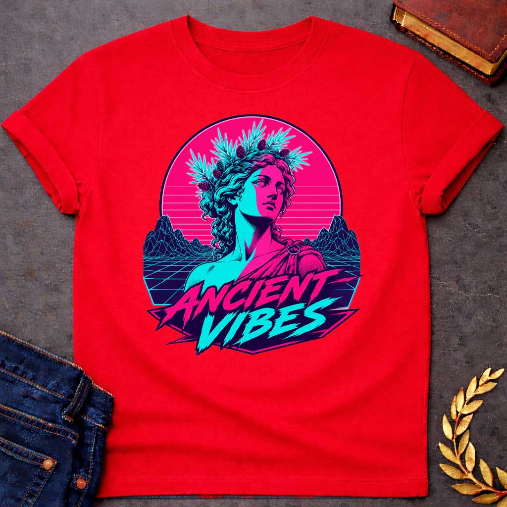 Red T-shirt with a Vaporwave-style illustration of a classical Greek Nymph bust in neon magenta and cyan. The figure wears a laurel wreath crown and draped robes with split-color digital aesthetic. Geometric mountains and grid pattern landscape create a retro 80s vibe. Horizontal scan lines suggest digital distortion. Bold text reads 'ANCIENT VIBES' in magenta and cyan with star accents. Navy blue border frames the design. Blends classical Greek aesthetics with modern synthwave style.
