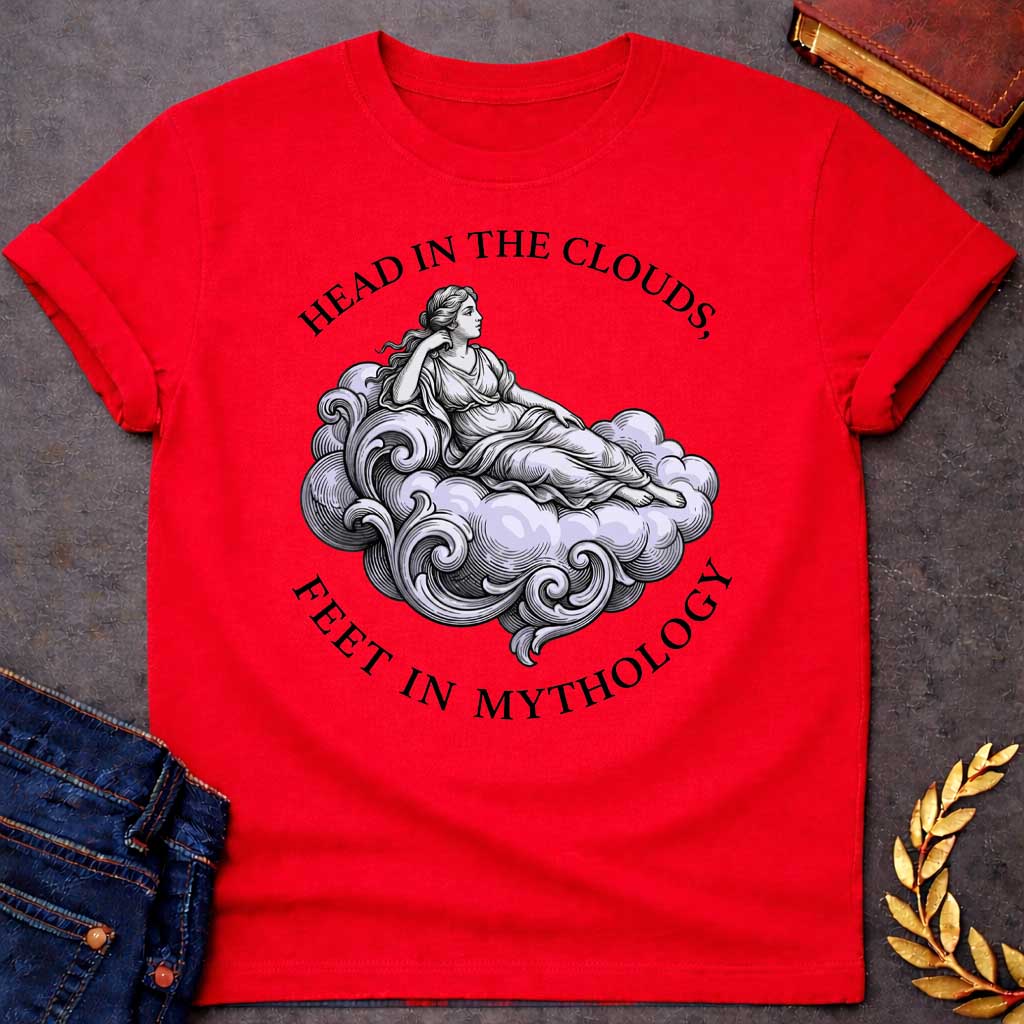 Red T-shirt with a classical Greek mythology t-shirt design featuring a detailed engraving-style illustration. A woman in a traditional draped chiton relaxes gracefully, reclining on a large, swirling baroque-style cloud shaded in a pale purple hue. Arched above her is the text "HEAD IN THE CLOUDS," and curved inversely below the cloud is "FEET IN MYTHOLOGY," all written in a clean black serif font.