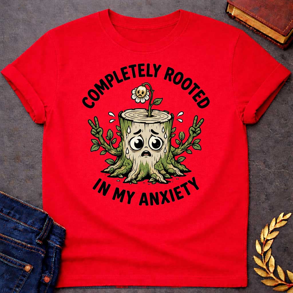 Red T-shirt with a cottagecore-style Greek mythology t-shirt design featuring an engraving illustration of a dryad. The flowing hair intricately weaves into a robust network of tree roots below. Arched elegantly above the portrait is the text "COMPLETELY ROOTED" in a clean black serif font.