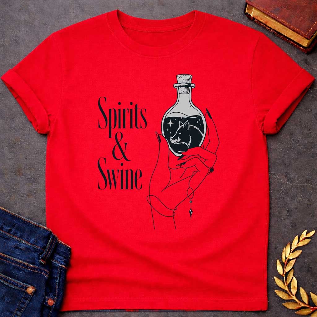 Red T-shirt with a Minimalist line art illustration of a mystical hand holding a potion bottle labeled 'Spirits & Swine.' Inside the dark bottle, a pig silhouette appears amid glowing stars and magical elements. The elegant hand wears decorative bracelets and rings. Black and white aesthetic with witchy, occult vibes. References Circe's legendary enchanted spirits that transformed men into swine. Celebrates ancient magic, potion-making, and mythological transformation with modern witchcraft themes.