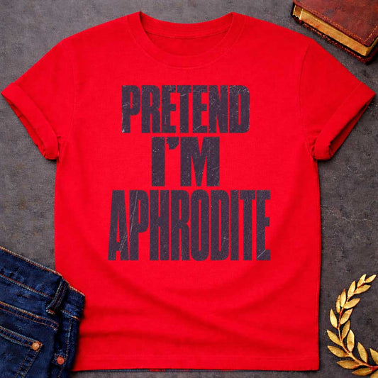 Red t-shirt with a Pretend I’m Aphrodite Greek mythology design featuring bold distressed purple typography on a transparent background. The stacked text reads “PRETEND I’M APHRODITE” in a rugged vintage block font, creating a simple humorous design inspired by Aphrodite, the Greek goddess of love and beauty.