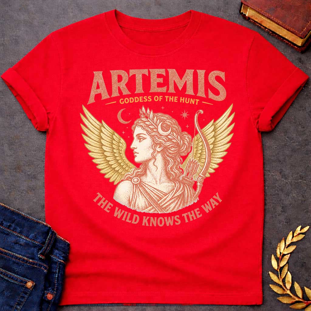 Red t-shirt with a Vintage Greek mythology design featuring Artemis, goddess of the hunt, with a crescent moon, stars, bow and arrows, and golden wings. Warm coral and gold engraving-style artwork frames her classical portrait. Bold text reads "Artemis – Goddess of the Hunt" and "The Wild Knows the Way," celebrating the Olympian goddess of nature and the hunt.
