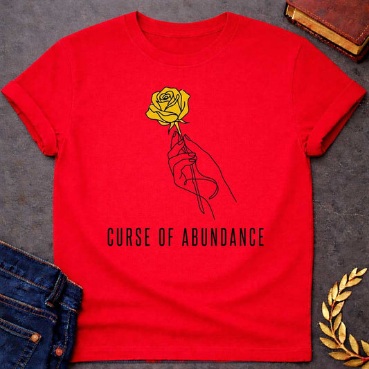 Red t-shirt with A Minimalist Greek mythology design featuring a continuous line-art hand delicately holding a golden rose, symbolizing King Midas' legendary golden touch. Below the illustration, the phrase "Curse of Abundance" appears in clean, modern typography. A simple black-and-gold aesthetic creates an elegant, understated design inspired by the tragic Midas myth.