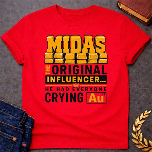 Red t-shirt with A Bold typographic Greek mythology design featuring stacked gold bar lettering spelling "MIDAS" above the phrase "The Original Influencer... He Had Everyone Crying Au." The design uses distressed black and metallic gold typography with a small crown icon and a gold-themed chemical element "Au" symbol, creating a humorous King Midas pun in a vintage-inspired graphic style.

