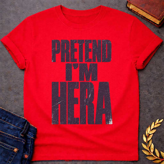 Red t-shirt with a Pretend I’m Hera Greek mythology design featuring bold distressed dark purple typography on a transparent background. The stacked text reads “PRETEND I’M HERA” in a rugged vintage block font, creating a humorous design inspired by Hera, the Greek goddess of marriage, women, family, and queen of the Olympian gods.