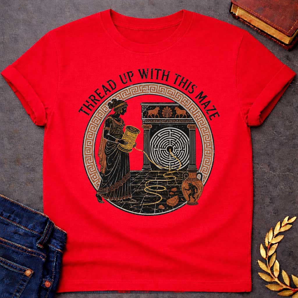 Red T-shirt with A distressed, ancient Greek pottery-style t-shirt graphic. Inside a circular terracotta Greek key frame, a black figure of Ariadne holds a large spool, unwinding a golden thread that leads into a circular maze on a stone structure. An amphora vase with a Minotaur stands nearby. Arched above the scene, black text reads "THREAD UP WITH THIS MAZE" in a rustic serif font.