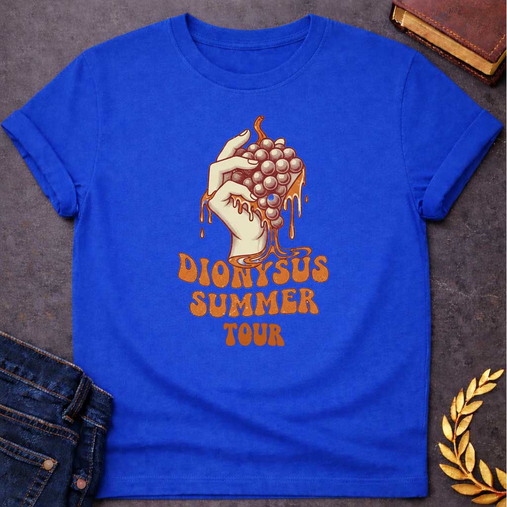 Royal Blue T-shirt graphic featuring a vintage-style illustration of a hand squeezing a bunch of grapes with juice dripping down, rendered in a retro halftone print style in cream and burnt orange tones.  Bold groovy retro lettering below reads "Dionysus Summer Tour," inspired by 1970s rock concert merchandise design