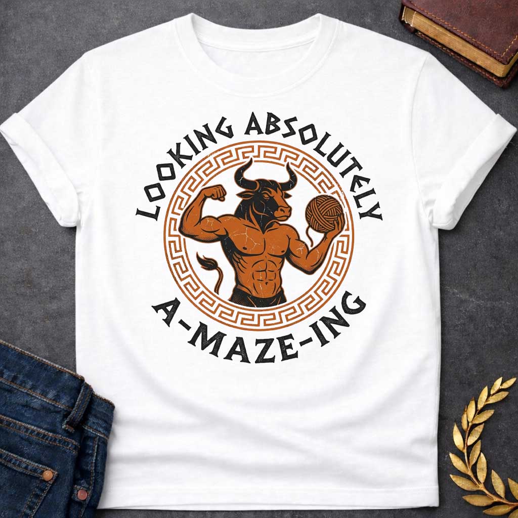 White T-shirt with a Fitness-themed design of a muscular Minotaur displaying impressive abdominal definition and flexing one arm. The bull-headed figure holds a ball of yarn in the other hand, referencing the mythological thread used to escape the labyrinth. Terracotta orange and brown coloring with defined musculature. Greek key pattern border frames the circular composition. Text reads 'Looking Absolutely A-Maze-Ing' in bold black lettering. Clever wordplay blends gym culture with Greek mythology.