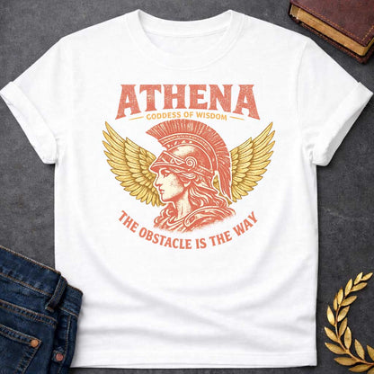 White t-shirt graphic featuring a side-profile illustration of Athena wearing a Corinthian helmet with a red plume, flanked by large golden wings. Text reads "ATHENA – Goddess of Wisdom" arched above and "The Obstacle Is the Way" curved below, in a vintage Greek mythology style with rose and gold tones